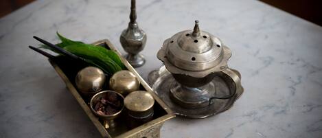 Una bandeja de bronce con un juego de té sobre una mesa de mármol.