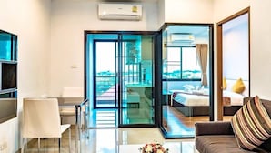 Una habitación de hotel moderna con balcón, comedor y sala de estar.