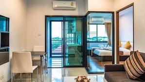 Una habitación de hotel moderna con balcón, comedor y sala de estar.
