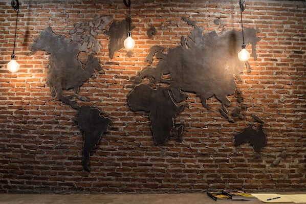 Explore the world from the comfort of this unique space, featuring a large map mural on a brick wall.