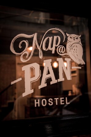 Una finestra amb el text "Nap@PAN HOSTEL" i una representació gràfica d'un olivera.