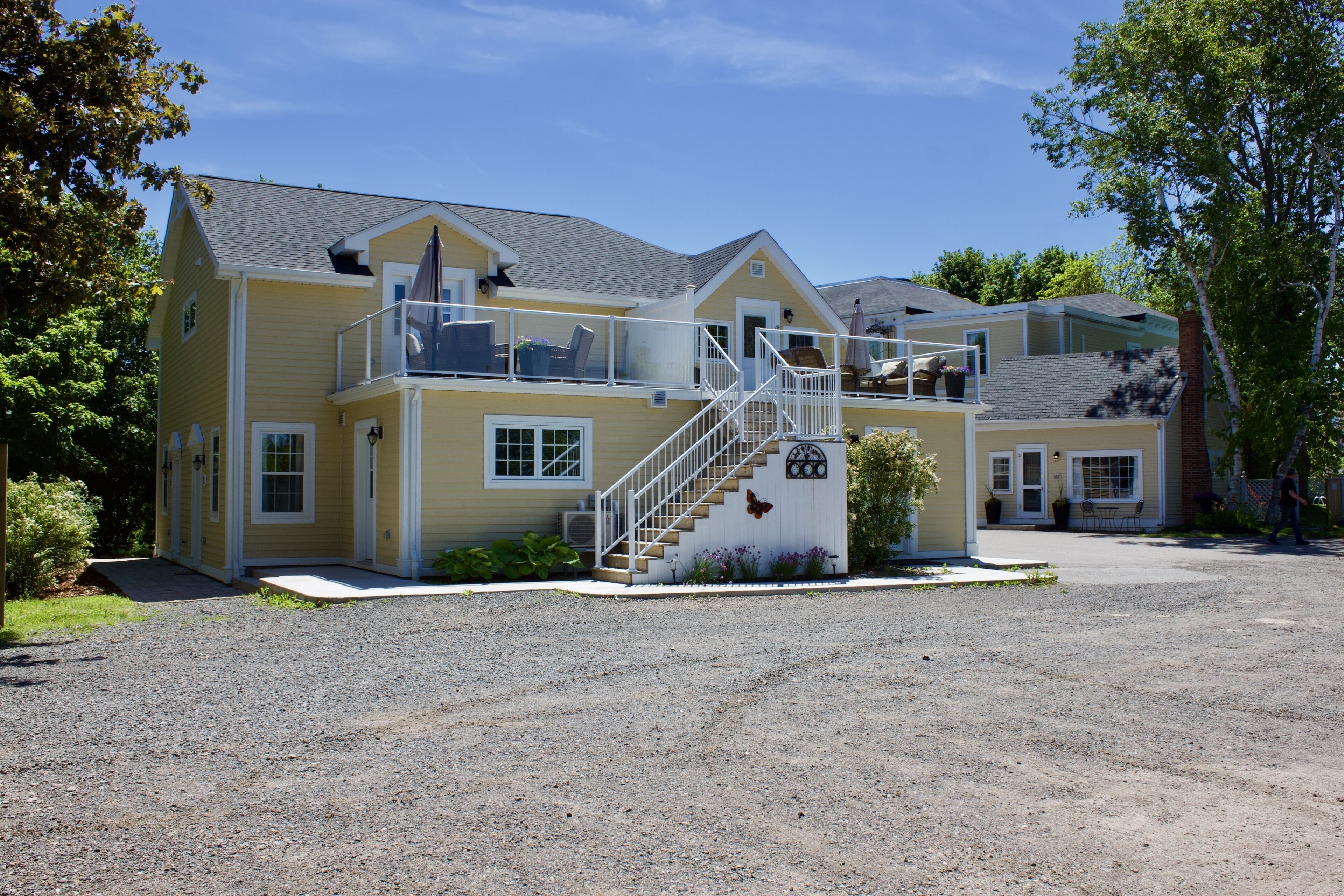 A two-story building with a balcony, a staircase, and a front entrance.