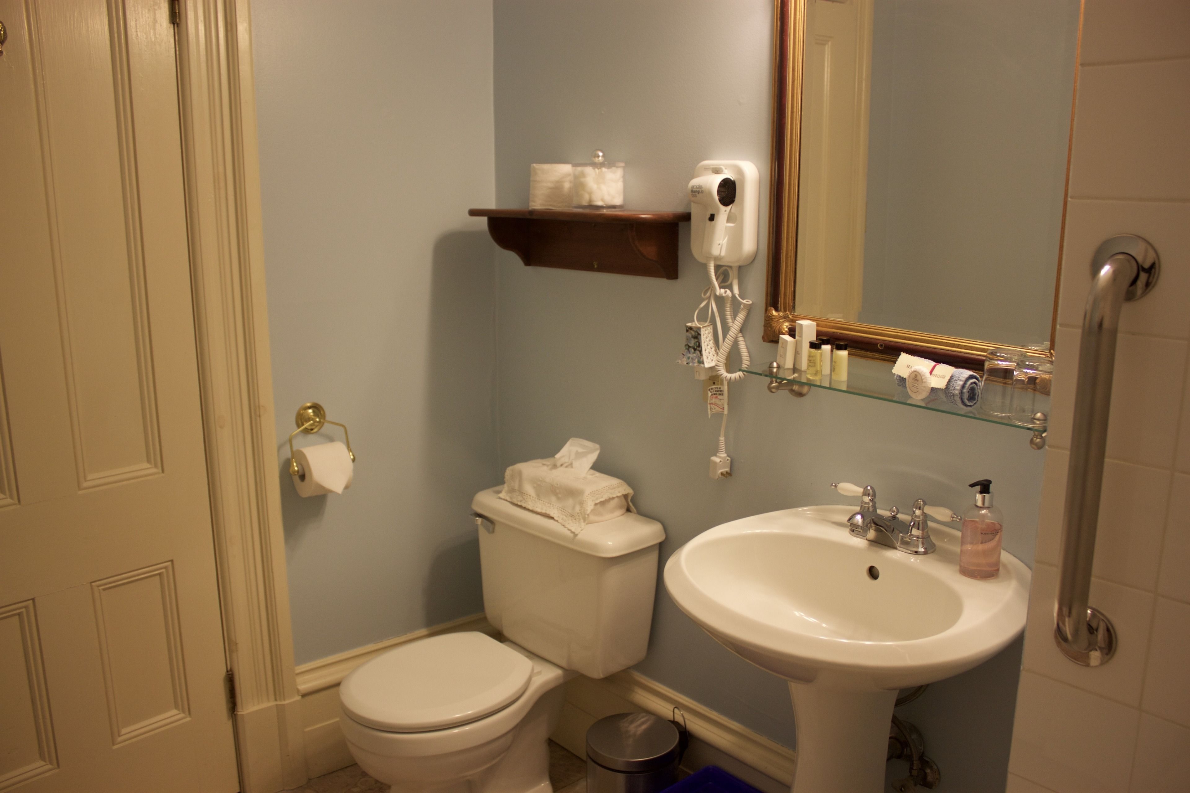 A bathroom with a toilet, sink, and a towel rack.