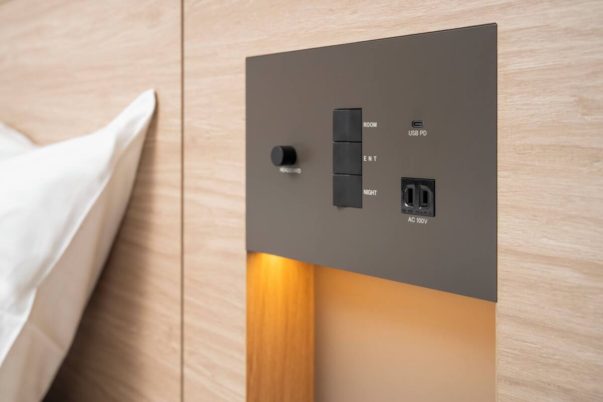 Een bedieningspaneel met een schakelaar waarop 'KAMER' en 'ENTREE' staan voor kamer- en toegangsinstellingen, een USB PD-poort en een wisselcontact voor 100V.
