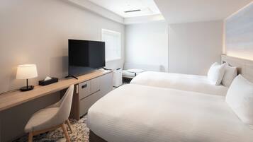 A hotel room with a bed, a desk with a chair, a television, and a window.