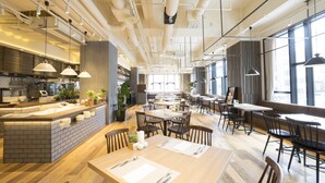 Un restaurant moderne doté d’un îlot central, de tables et de chaises en bois.
