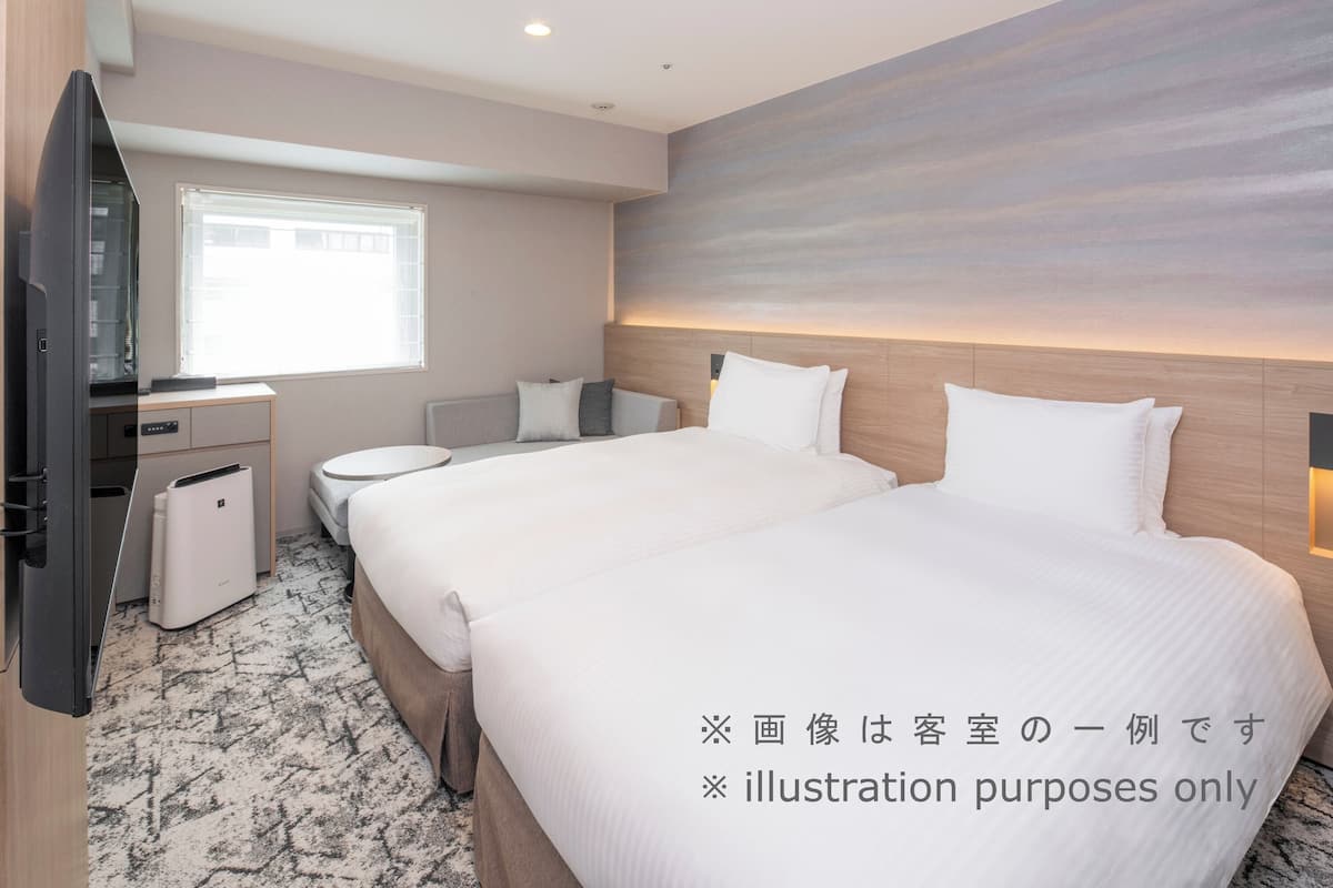 Une chambre d’hôtel avec un grand lit, un bureau, une chaise et un téléviseur.