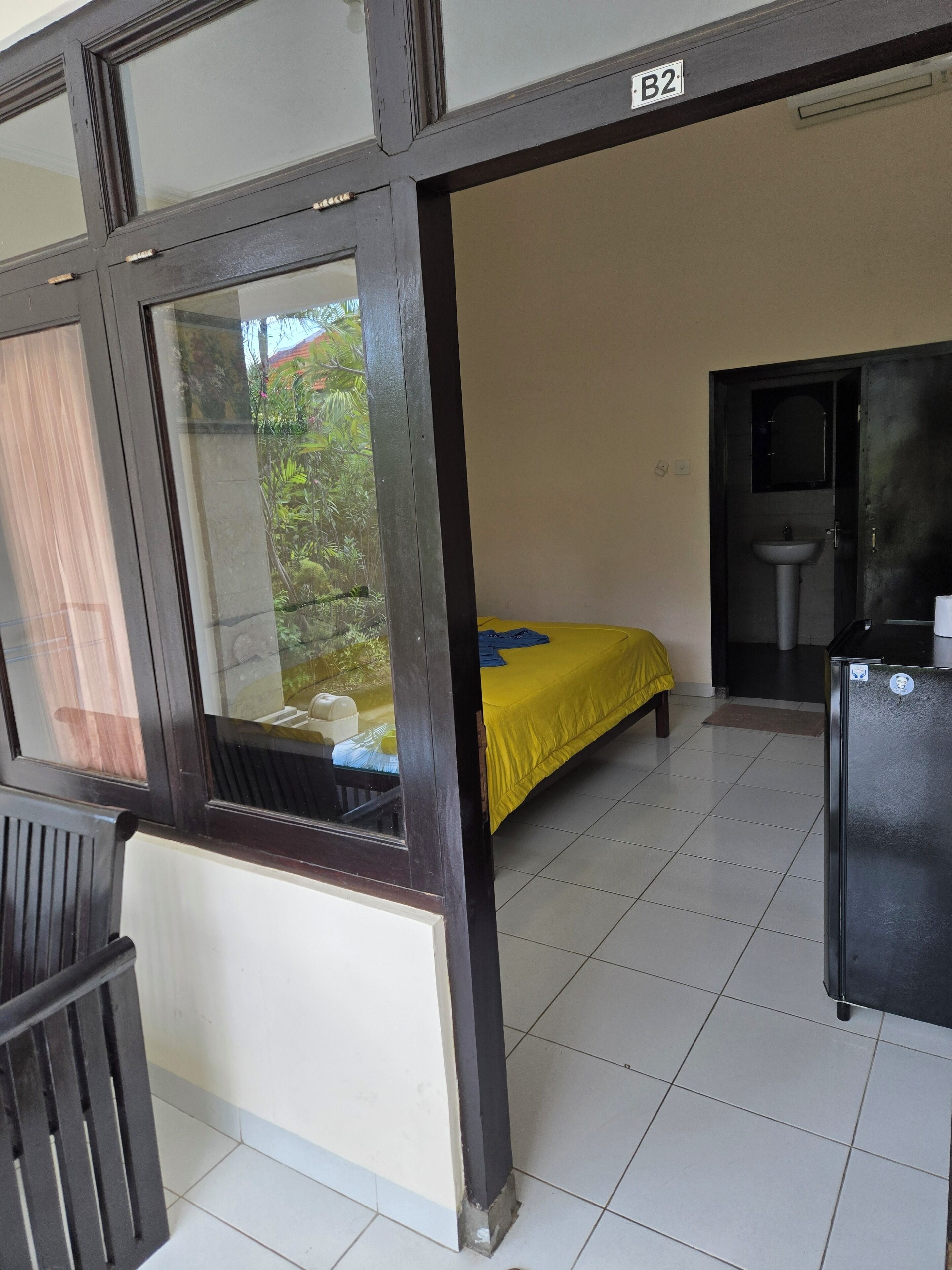 A room with a bed, a sink, and a refrigerator.