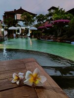 Una piscina al aire libre, sombrillas, sillones reclinables de piscina