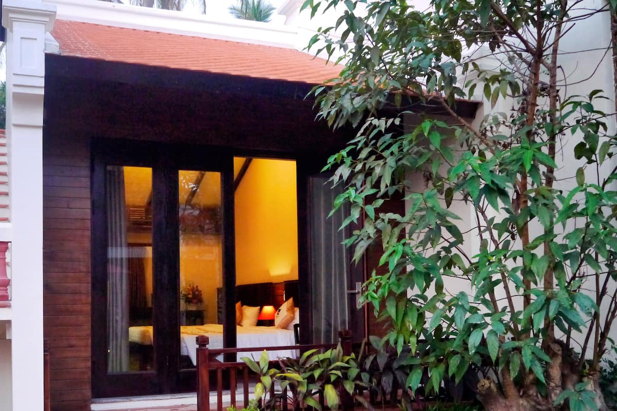 A house with a front porch, a small garden, and a window with a view of the interior.