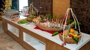 A buffet setup with various food items and decorative elements. - Sea Queen Hotel (Da Nang)