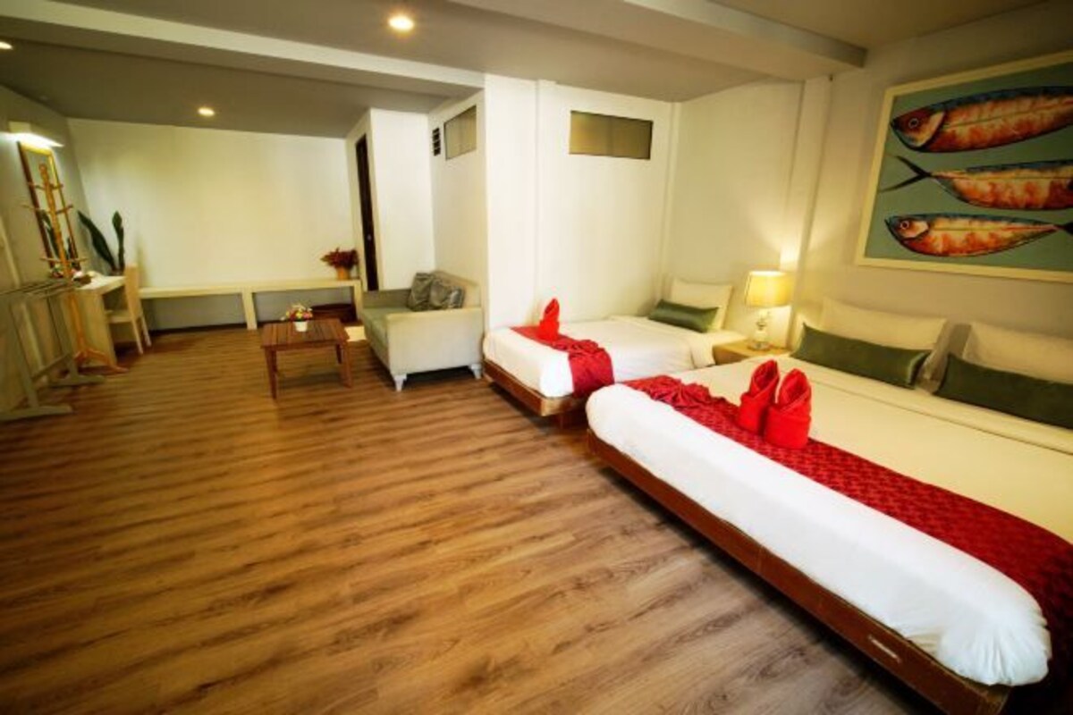 Een hotelkamer met twee bedden, een bureau, een stoel en een televisie.