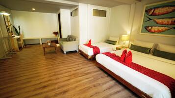 A hotel room with two beds, a desk, a chair, and a TV.
