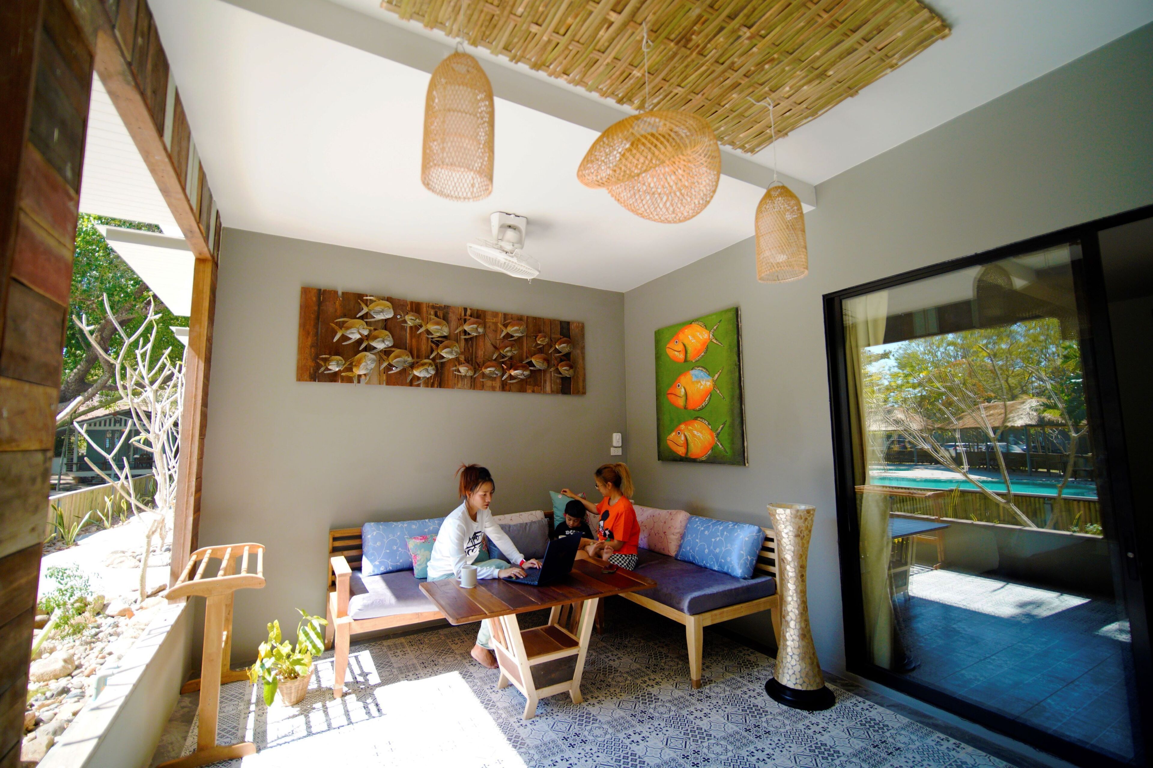 Una habitación con una mesa de madera, un sofá y un ventanal grande.