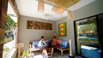 Una habitación con una mesa de madera, un sofá y un ventanal grande.