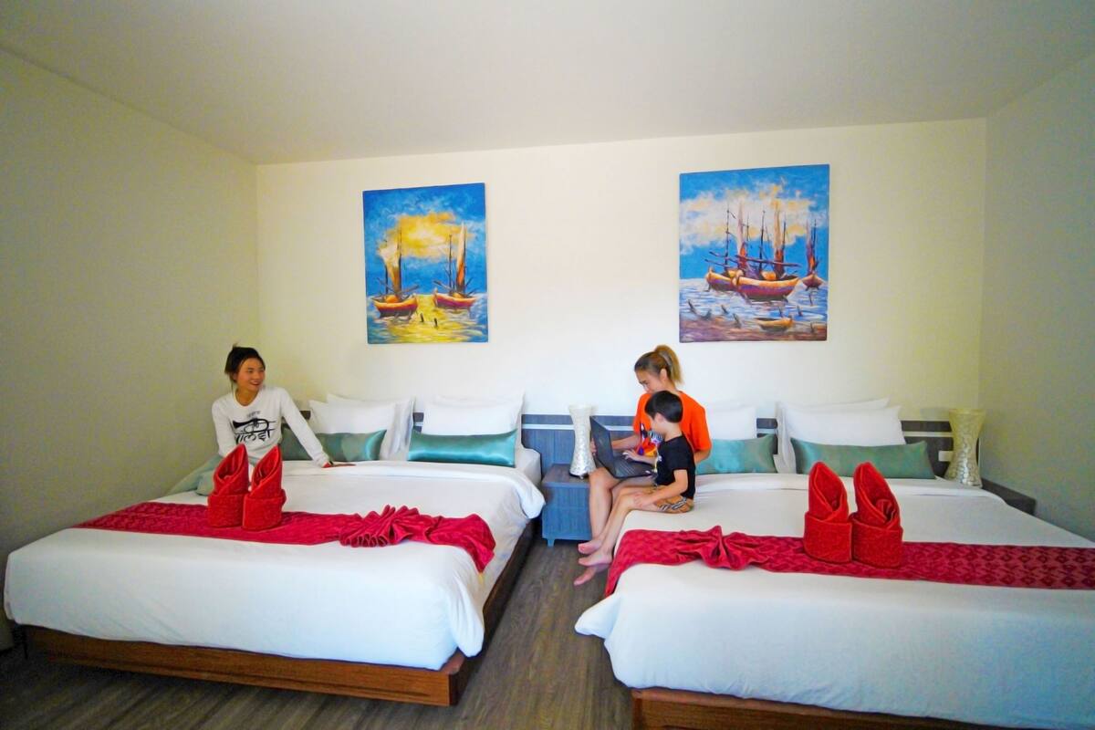 Une chambre d’hôtel avec deux lits, une table de chevet et des œuvres d’art représentant des bateaux.