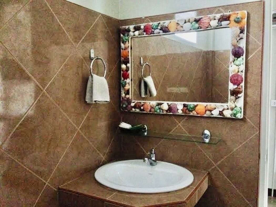 A bathroom with a sink, mirror, towel rack, and decorative tiles.