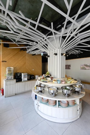 A buffet setup with a central serving area and multiple food stations. - R7 Eco Hotel (Kaohsiung)