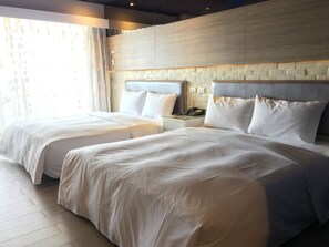 A hotel room with two beds, a brick accent wall, and a nightstand with a phone. - R8 Eco Hotel (Kaohsiung)