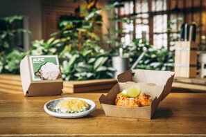 Enjoy a meal in a cozy dining area with a view of lush greenery.