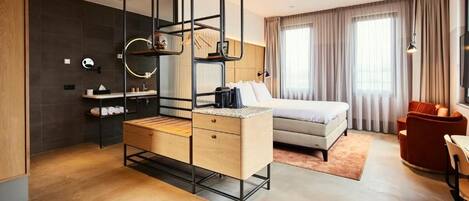 Une chambre d’hôtel moderne équipée d’un lit, d’une table de chevet et d’un bureau avec une chaise.