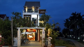 A two-story building with a balcony and a restaurant entrance. - Azalea Homestay (Da Nang)