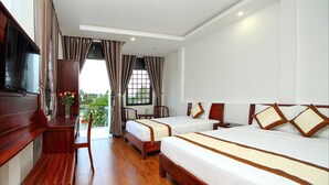 A hotel room with two beds, wooden furniture, a TV, and a window with curtains. - Azalea Homestay (Da Nang)