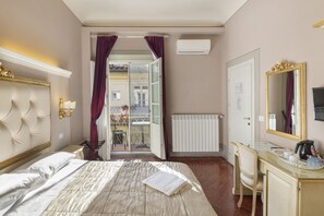 Ett hotellrum med en säng, ett skrivbord, en stol, ett fönster med gardiner, ett element och en spegel.
