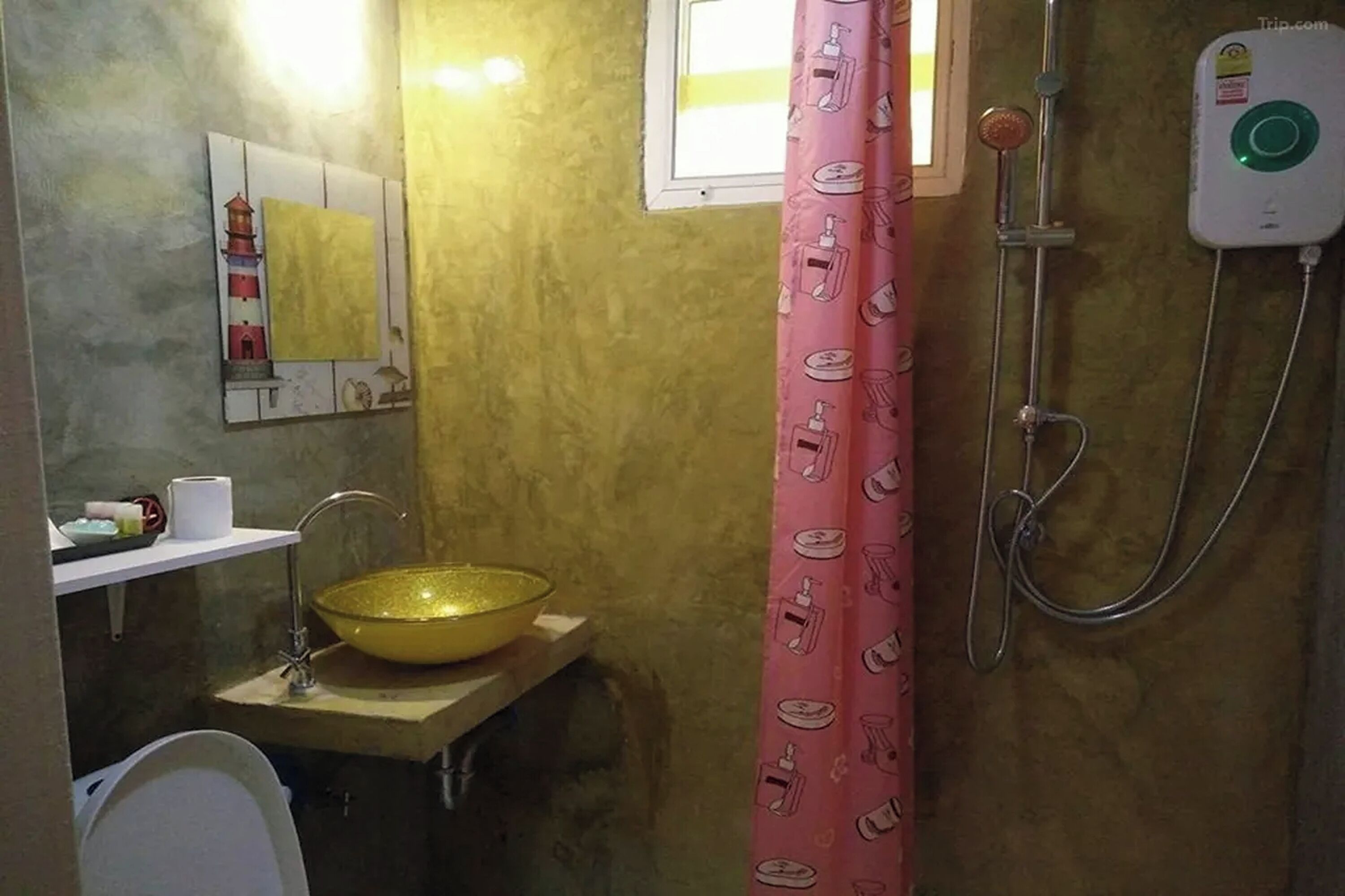 A bathroom with a yellow sink, a mirror, a shower, and a pink shower curtain.