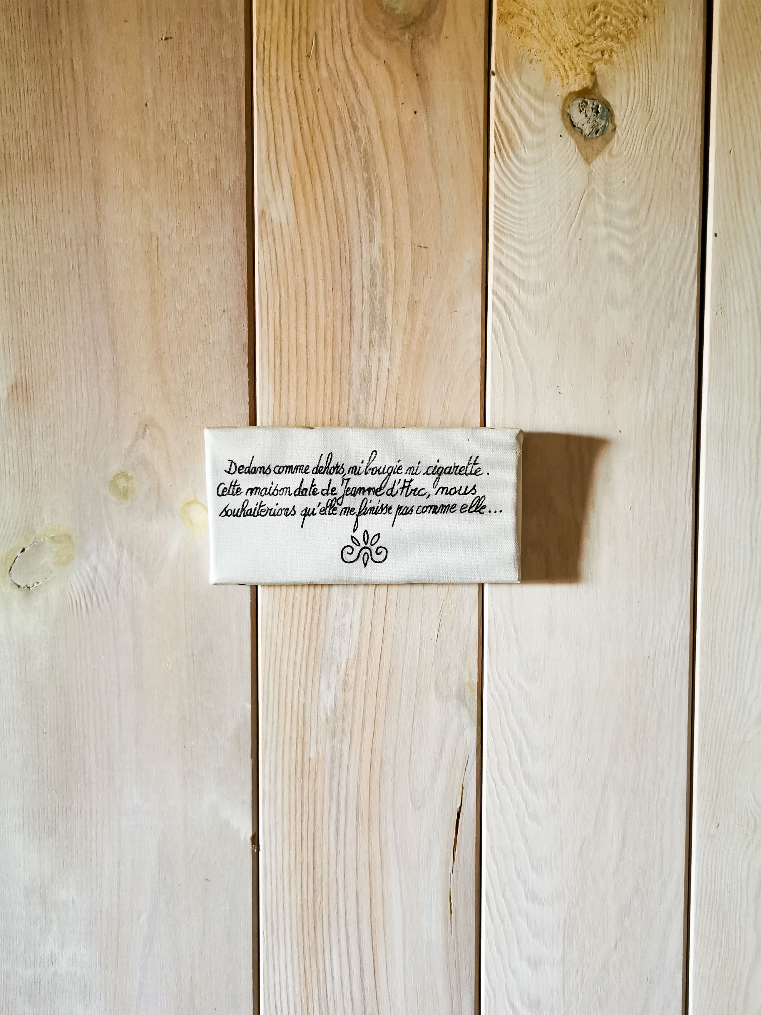 Superficie de madera con una etiqueta blanca que contiene texto.