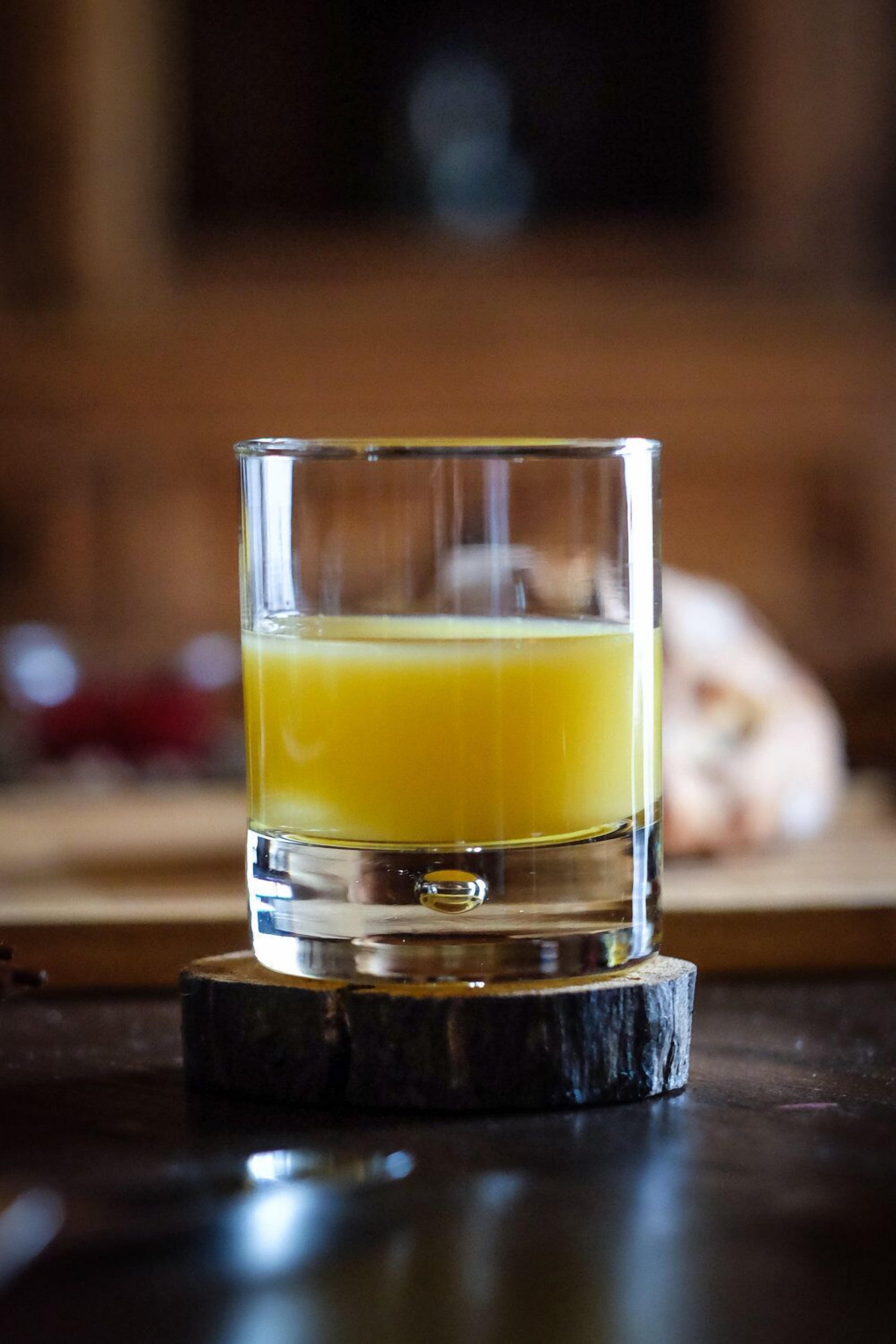 Un bicchiere di succo d'arancia su un sottobicchiere.