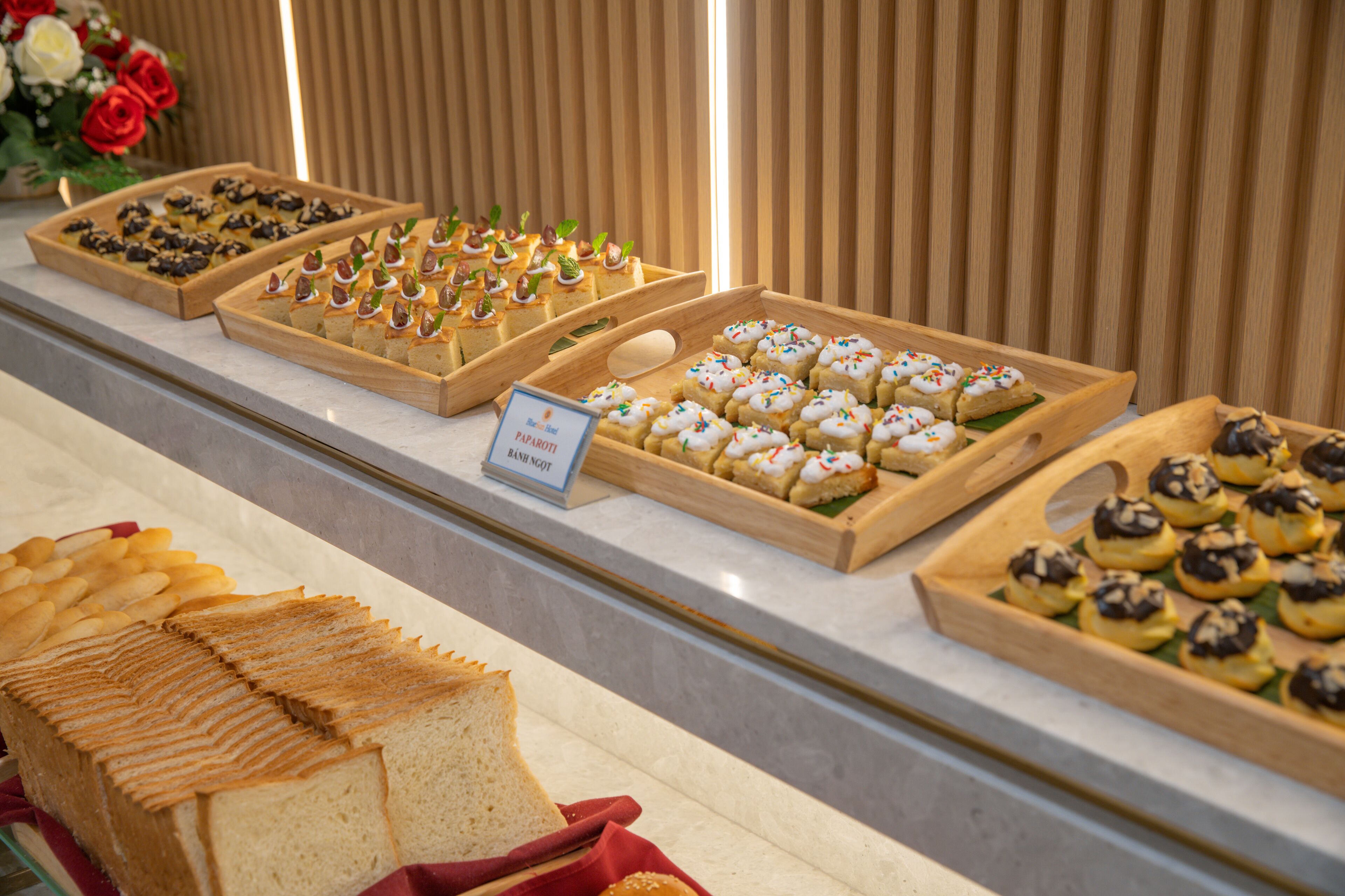 A buffet with various food items including bread, pastries, and desserts.