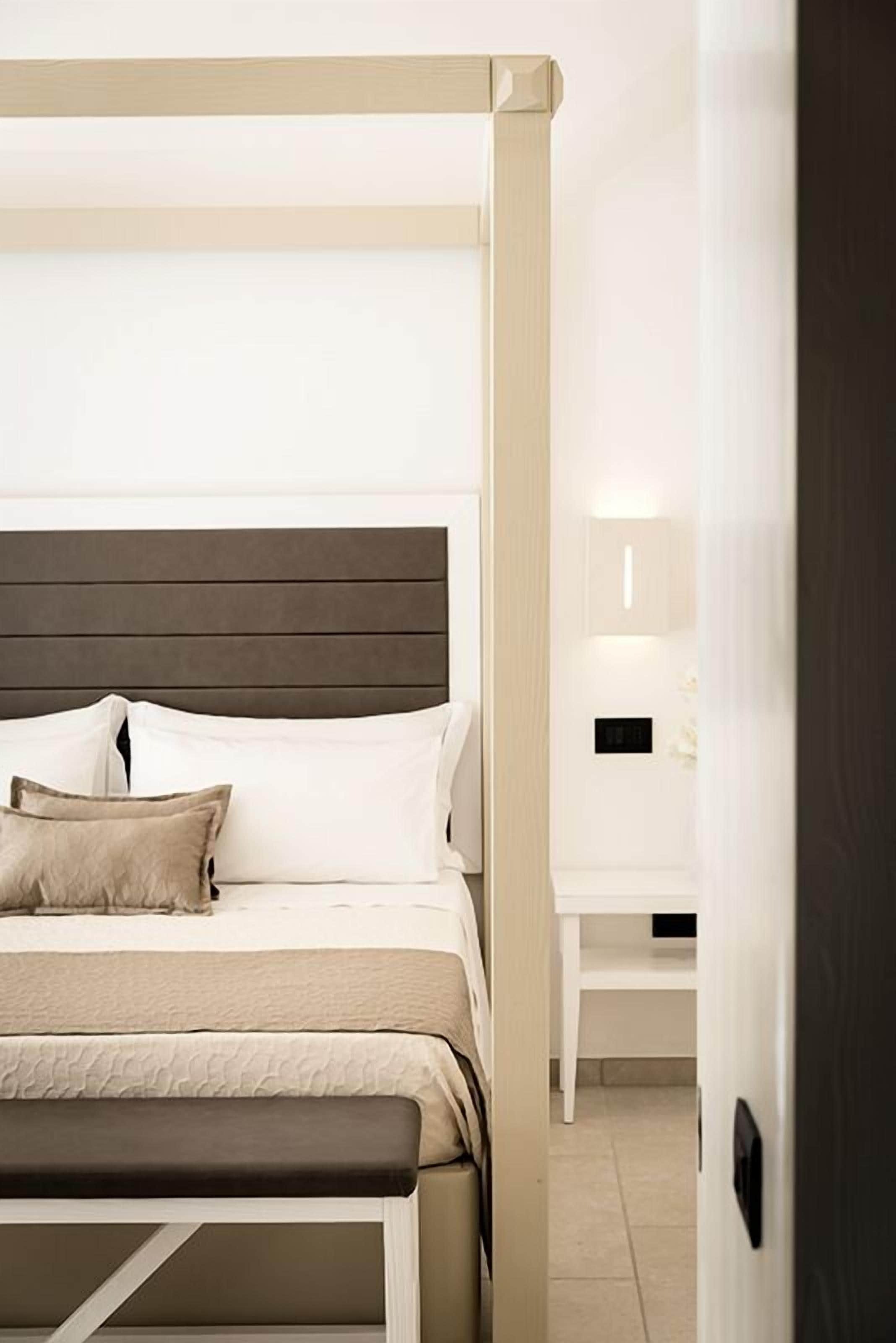 A modern bedroom with a bed, bedside table, and a bench.