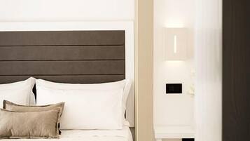 A modern bedroom with a bed, bedside table, and a bench.