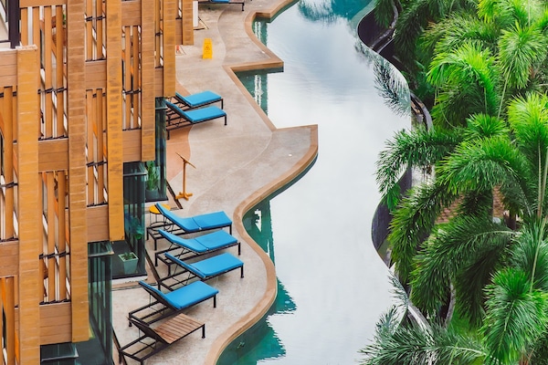 Una piscina al aire libre, sillones reclinables de piscina