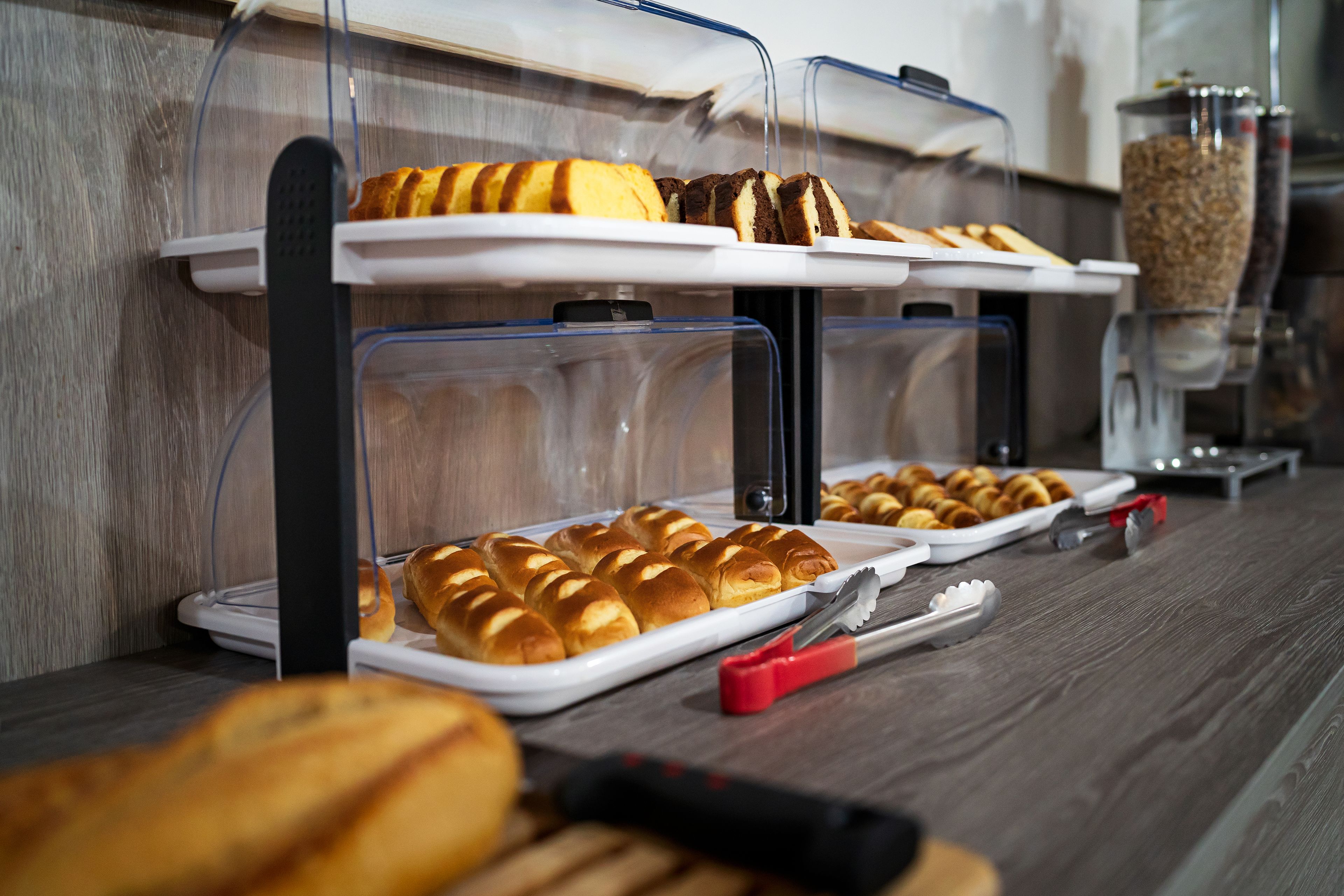 Un buffet proposant une variété de produits de boulangerie et d’ustensiles.