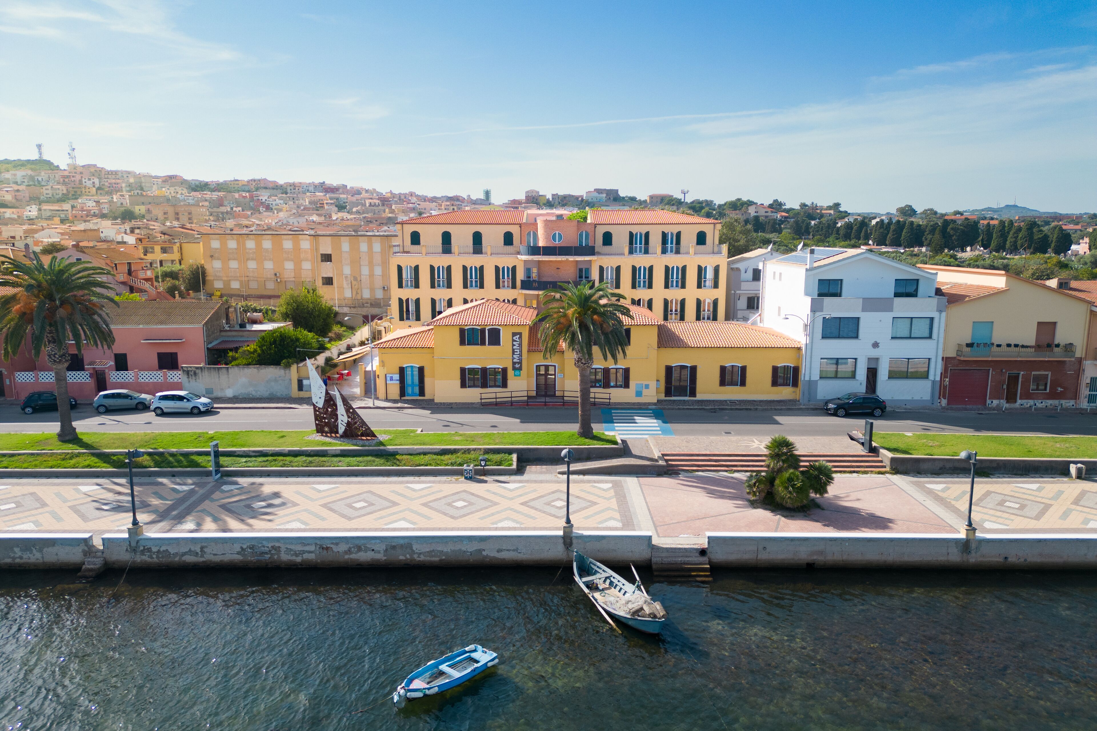 Una propiedad frente al agua con un canal, barcos y edificios con balcones.