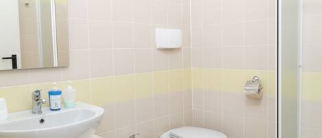 Ein Badezimmer mit Waschbecken, Bidet, Toilette und Spiegel.