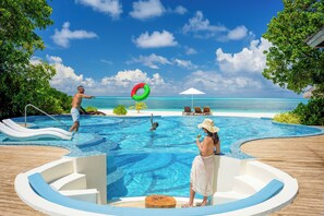 A pool area with a view of the ocean, lounge chairs, and a hot tub. - Atmosphere Kanifushi - Premium All Inclusive with Free Transfers (Kanifushi)