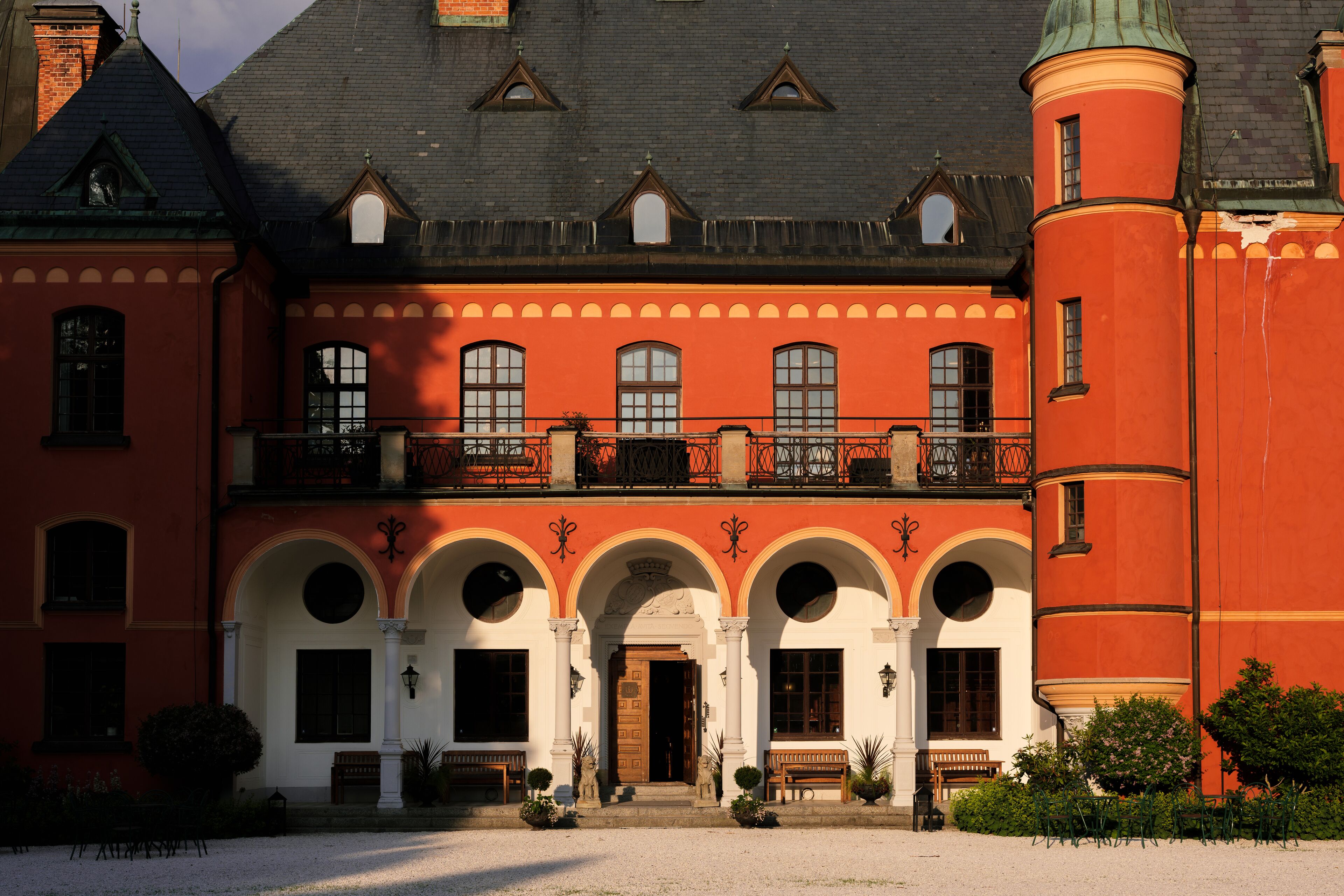 Un grand bâtiment historique à la façade symétrique, doté de nombreuses arcades et d’une entrée centrale.