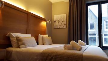 Enjoy a restful night's sleep in this stylish hotel room featuring a large bed and a beautiful city view.