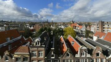 A view of a densely packed urban area with traditional European architecture, including red-tiled roofs and gabled facades.