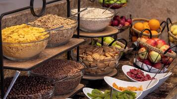 Un bufé con diversos alimentos, entre ellos frutas, frutos secos y cereales.