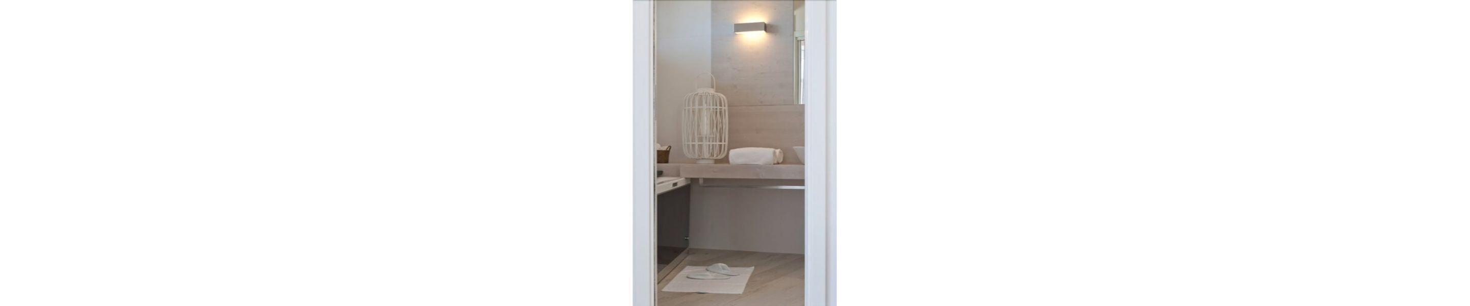 A bathroom with a white towel on the floor, a white towel on the counter, and a white hanging towel.
