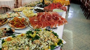 Una mesa de buffet con diversos platos, incluyendo mariscos, ensaladas y carnes.