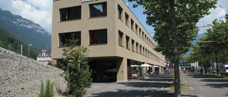 A Youth Hostel with a modern design, featuring multiple windows and a flat roof.