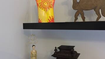 A shelf with a decorative vase, a figurine, and a clock.