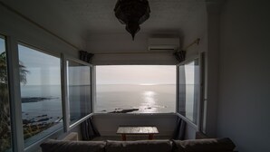 A room with a view of the ocean, a sofa, and a small table. - Hotel Boutique Milla de Plata (San Roque)