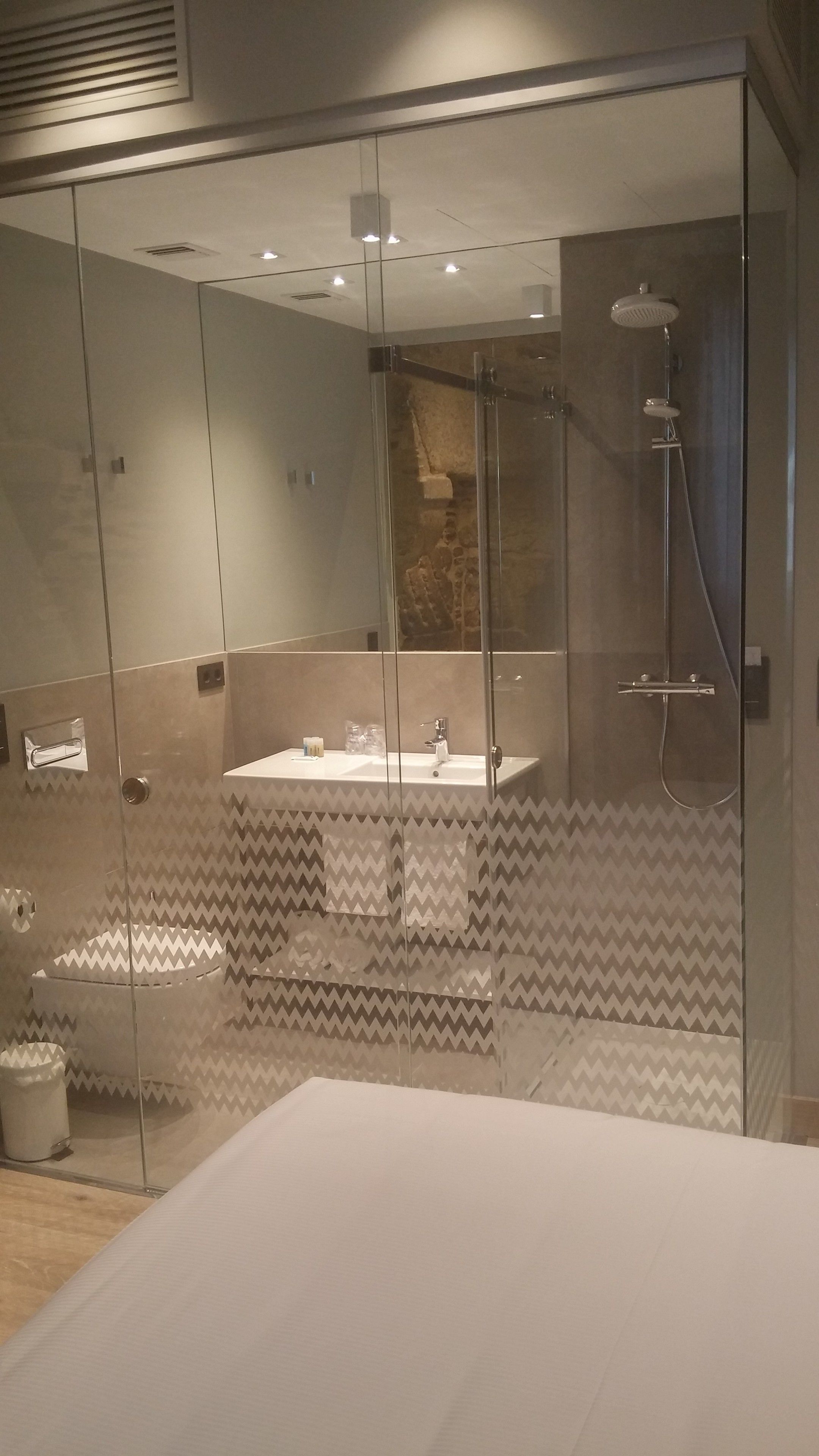 Une salle de bain moderne avec une douche à parois de verre, un meuble-lavabo et un miroir.