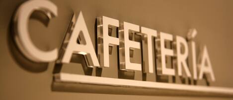 A metallic sign with the word "CAFETERIA" in capital letters.
